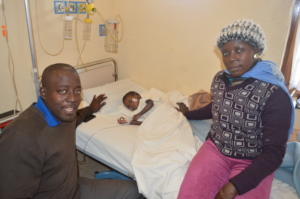 Elisee in the ward after surgery with her parents
