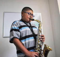 Isaiah practices his saxophone.