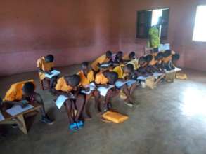 Primary 4 Pupils writing exams on benches