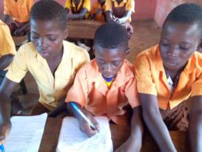 Wasaak (Middle) and colleagues writing in class