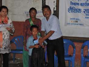 Distributing education materials to a Chepang kid