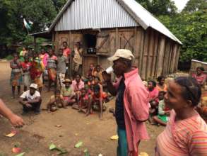 A community member takes a drink from a well