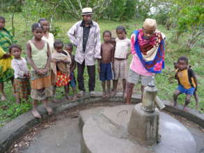 Community members standing around a well