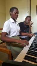 Kiconco in a piano lesson