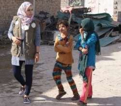 Female lawyer with young girls in displaced camp