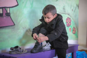 Mohammad putting on his new shoes