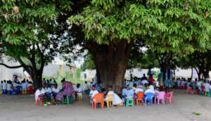 Class under trees, waiting for their new school!