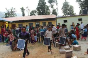 Villagers collect solar sets during distribution
