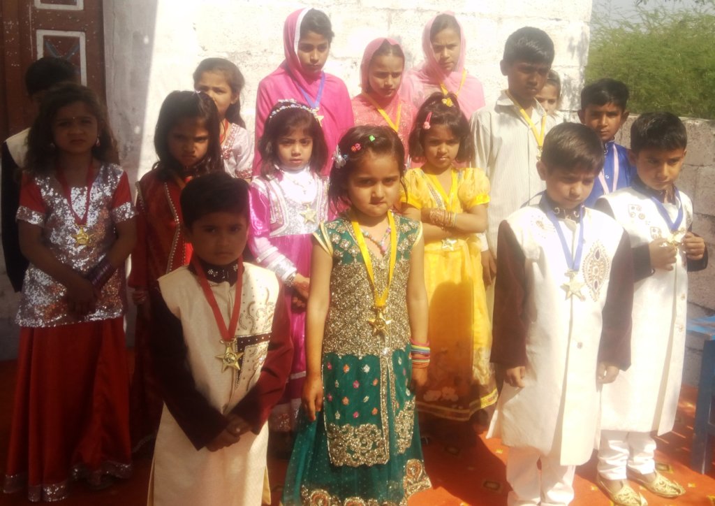 Students in colorful dresses with prizes.