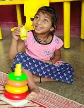 Charithriya enjoys playing with stacking ring toys