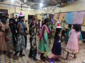 Children singing and dancing around Christmas tree
