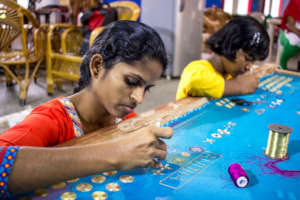 Anitha learning how to do Muggam work.