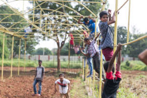 Kids playing on the bones of the greenhouse.
