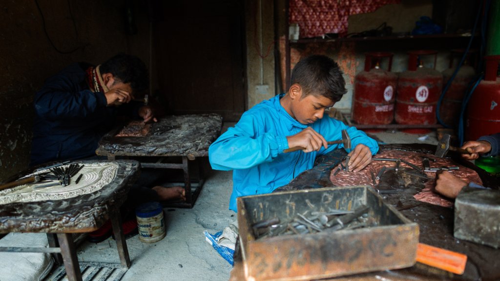 Young boys working in a metal factory