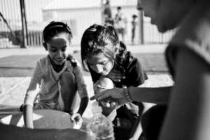 Two girls cooking in Larissa camp in Greece