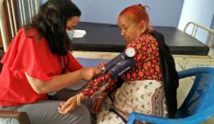 Sangita measuring blood pressure at health post