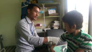 DFN medical student Dhanendra treating young boy