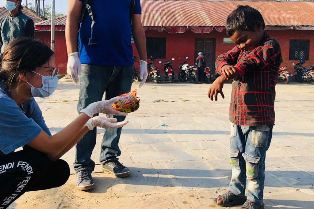 Yuna hands out food in the streets of Kathmandu