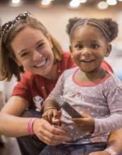 Staff member plays with Samantha, 2, at a shelter
