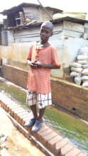 One of the children standing in front of the home