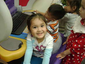 Preschoolers play learning games on computers
