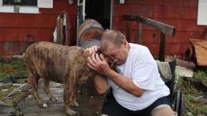 Hurricane Harvey survivor cries with his dog.