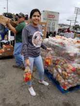 A Coastal Bend Volunteer helping distribute food.