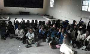 Children at the school sitting on dirty floors!