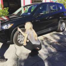 A volunteer learning to check tire pressure