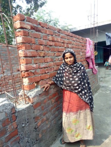 A woman in front of her house