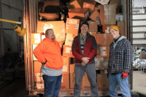 Mike, Dave, and Joel finish loading a container.