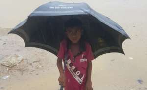A child shelters from the Monsoon rain.
