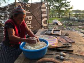 Woman making totopos in a destroyed kitchen