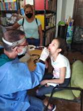 Medical team examines orphan girl's tonsils.
