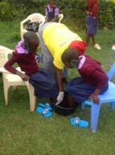 Gladys washing and sanitizing the student's feet