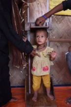 Shahera is being weighed, she is undernourished