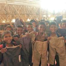 Students holding up their new pairs of pants