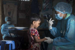 A child is seen by a doctor at the health post