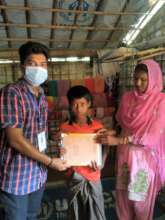 Staff giving books to  Rohingya kids