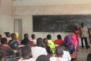 Coumba and her teacher in front of her classmates