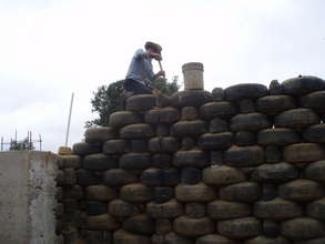 A member of the crew packs the tires with earth.