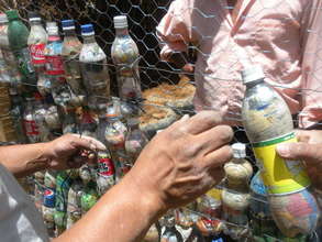 The crew places littter-filled bottles into walls.