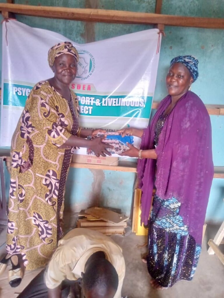 A recipient receiving her tailoring materials