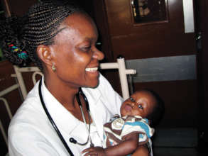 A health provider in Uganda holds her young charge