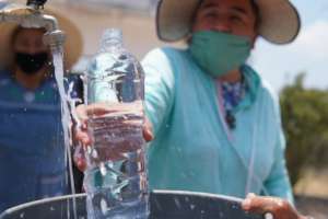 Community member takes a water samples at a well