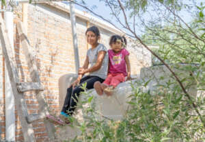 Sisters sitting on their new rainwater system