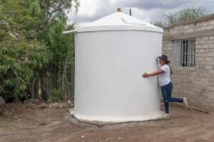 A woman embraces her new rainwater system