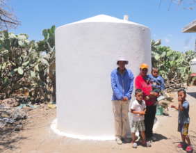 A family in Terreros in front of their new cistern