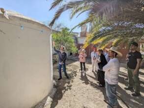 A resident explains a rainwater system to visitors