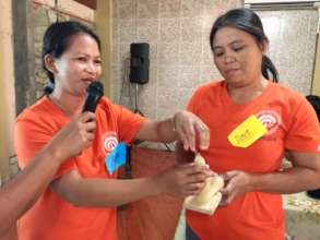 Health workers demonstrating how to use a condom
